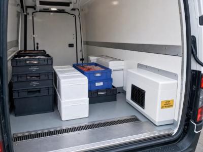 Een koelbestelwagen van binnen met geïsoleerde wanden, gekoelde kratten en een compacte koelunit voor betrouwbaar transport.