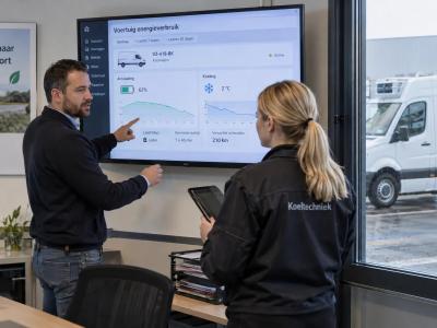 Een wagenparkbeheerder en monteur bespreken de energiebehoefte van een elektrische koelbus.