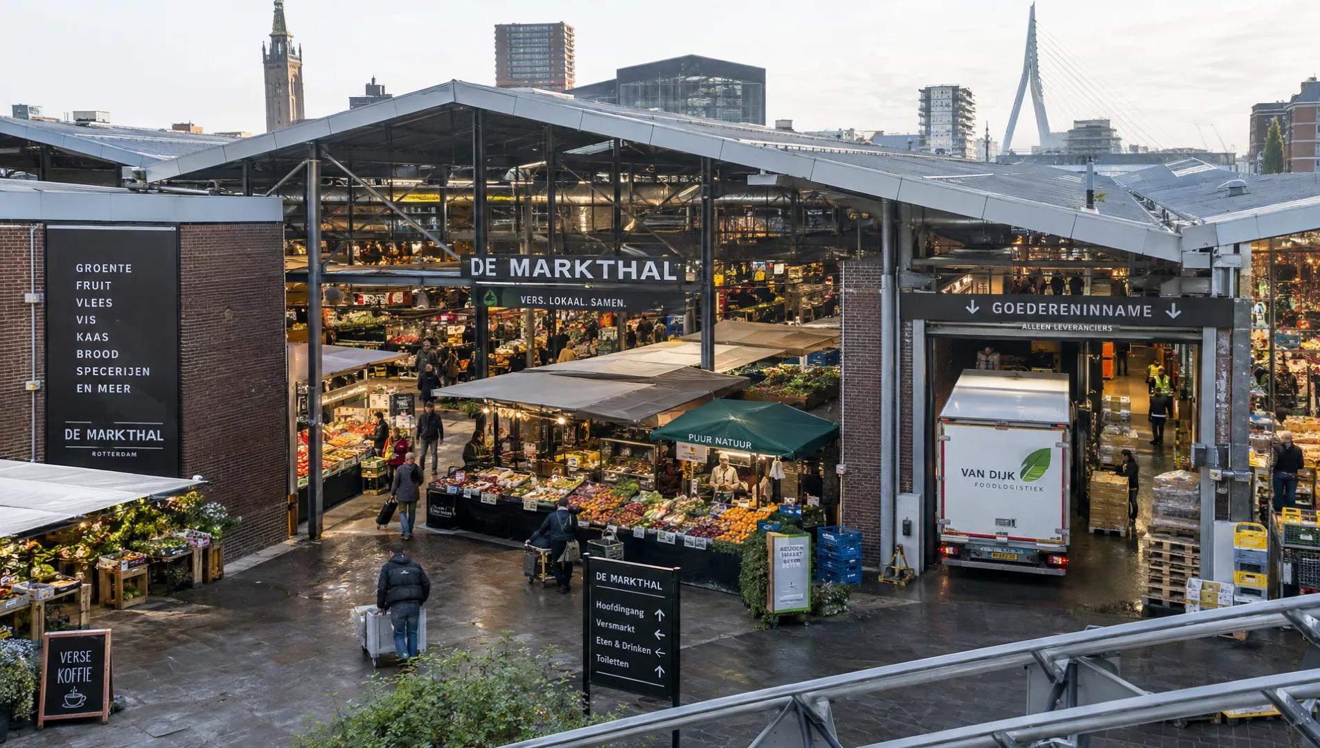 Een koelauto levert temperatuurgevoelige goederen bij een overdekte markt voordat de dagelijkse verkoop begint.